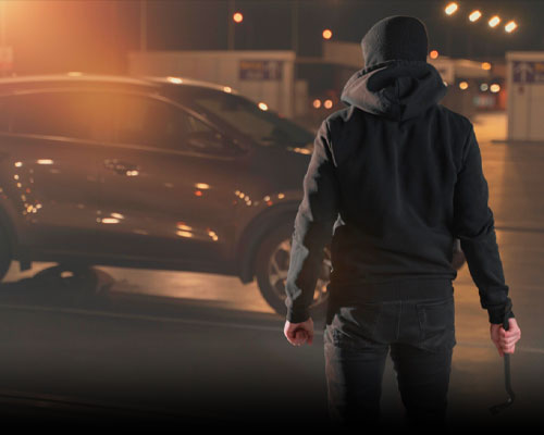 Person nähert sich nachts einem beleuchteten Fahrzeug